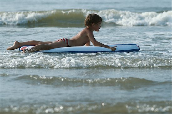 Boy floating on airbed in sea, s