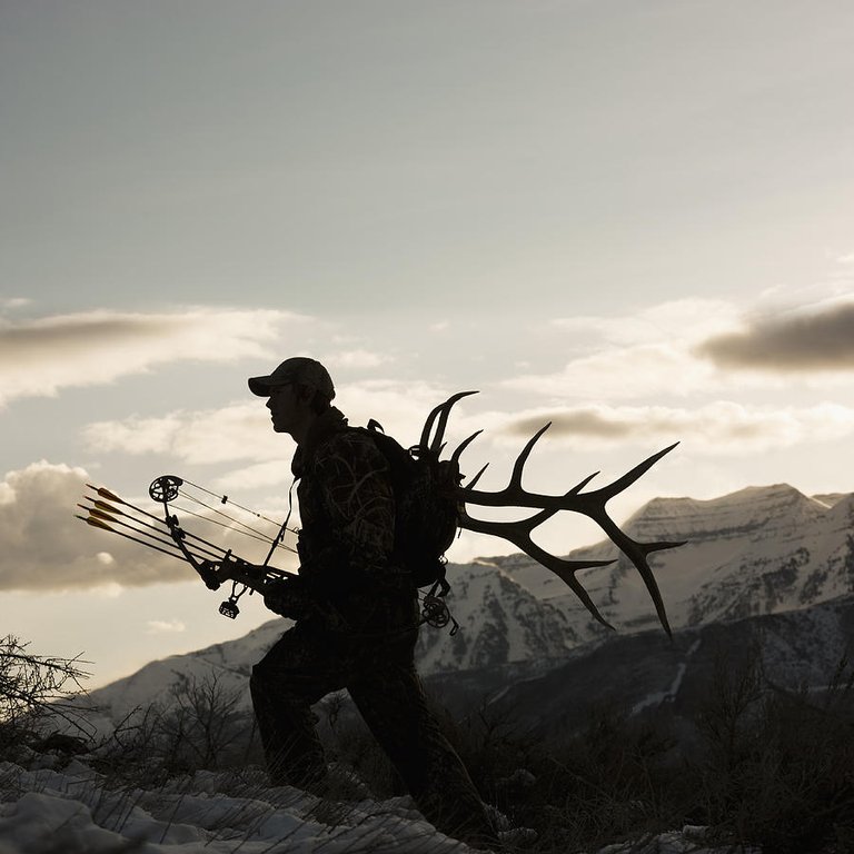 silhouette-of-hunter-hiking-with