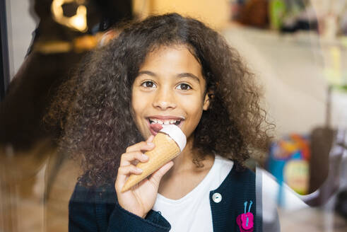 smiling-girl-eating-ice-cream-at-home-MOEF04434.jpg