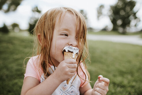 close-up-of-girl-eating-ice-cream-in-park-CAVF31849.jpg